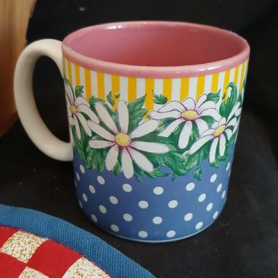 Two Garden Bloom placemats with fabric handmade apples in a basket, and mugs with a spoon rest