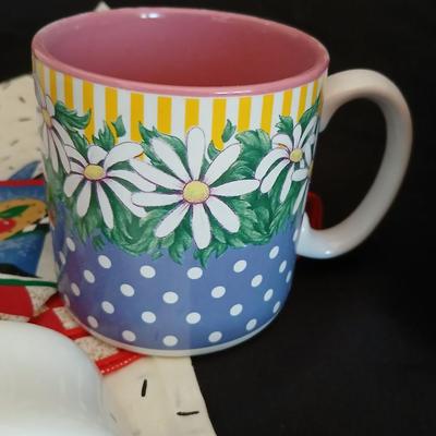 Two Garden Bloom placemats with fabric handmade apples in a basket, and mugs with a spoon rest
