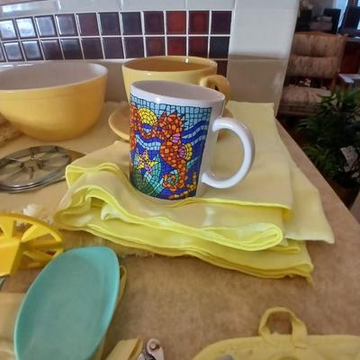 Kitchen items - placemats, small Pyrex mixing bowl, mug, napkins, kitchen towels, and more