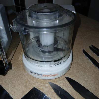 Chrome colored toaster with small electric chopper and wood handled knives