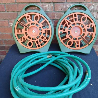 Two hose reels and a garden hose