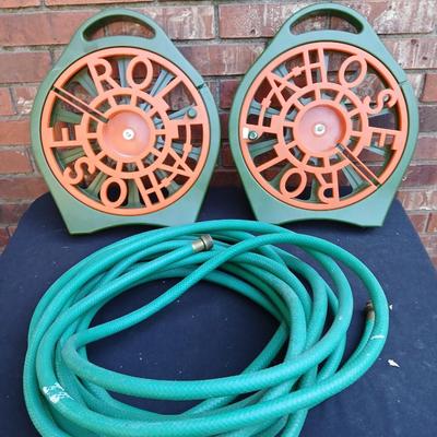 Two hose reels and a garden hose