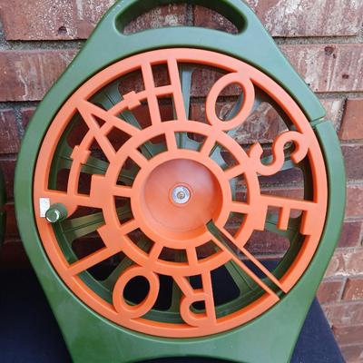 Two hose reels and a garden hose