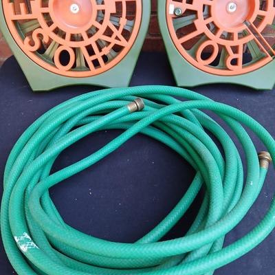 Two hose reels and a garden hose