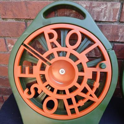 Two hose reels and a garden hose