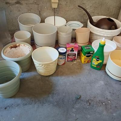 Assortment of plastic flowerpots with some plant food and more
