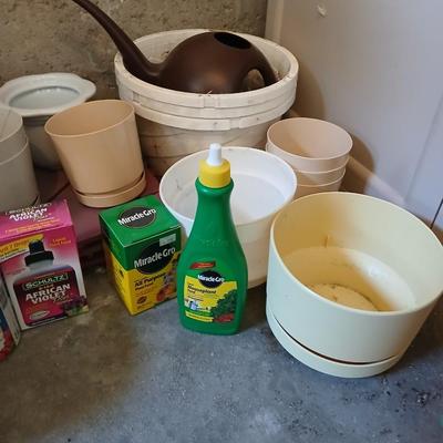 Assortment of plastic flowerpots with some plant food and more