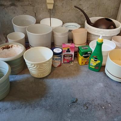 Assortment of plastic flowerpots with some plant food and more