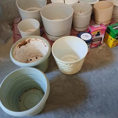 Assortment of plastic flowerpots with some plant food and more