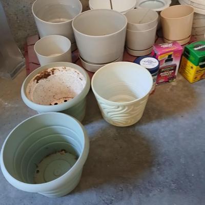 Assortment of plastic flowerpots with some plant food and more