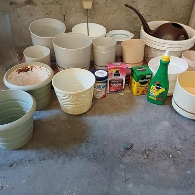Assortment of plastic flowerpots with some plant food and more