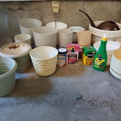 Assortment of plastic flowerpots with some plant food and more