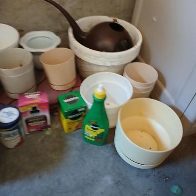 Assortment of plastic flowerpots with some plant food and more
