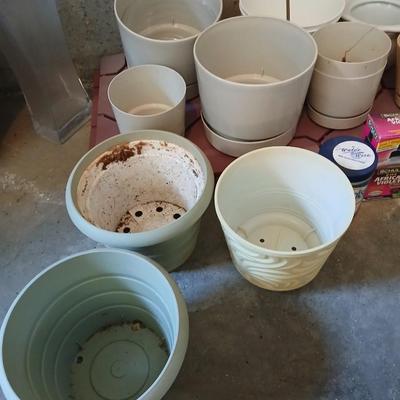 Assortment of plastic flowerpots with some plant food and more