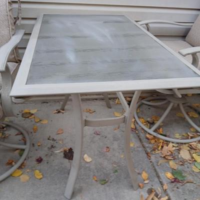 Two patio chairs and cushions with small glass topped patio table