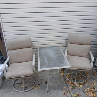 Two patio chairs and cushions with small glass topped patio table