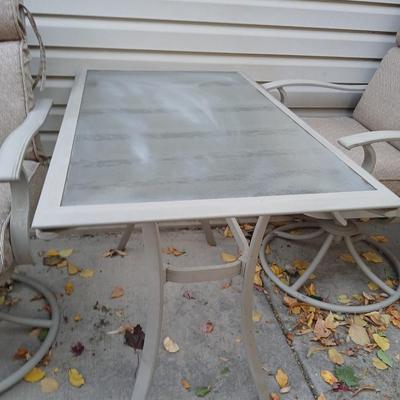 Two patio chairs and cushions with small glass topped patio table