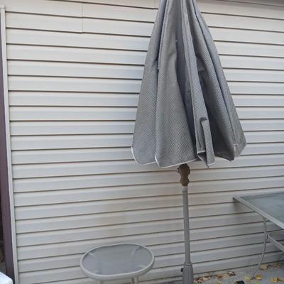 Brown Umbrella with stand and a small glass topped table