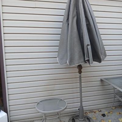 Brown Umbrella with stand and a small glass topped table