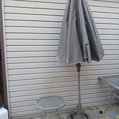 Brown Umbrella with stand and a small glass topped table