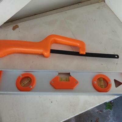 Grouping of orange tools, saws, level, strap wrench, flashlight, and more