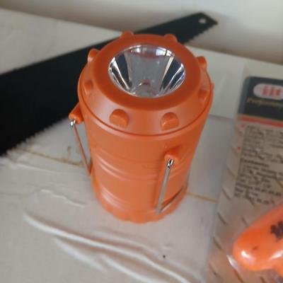 Grouping of orange tools, saws, level, strap wrench, flashlight, and more