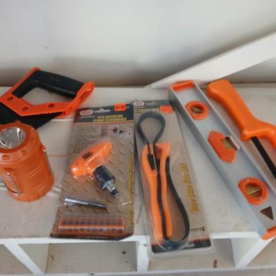 Grouping of orange tools, saws, level, strap wrench, flashlight, and more