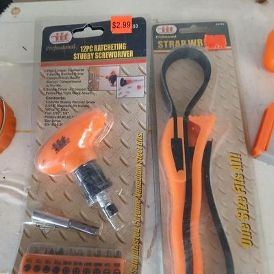 Grouping of orange tools, saws, level, strap wrench, flashlight, and more
