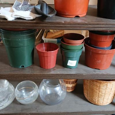 Lots of flowerpots and vases with a small metal shelf