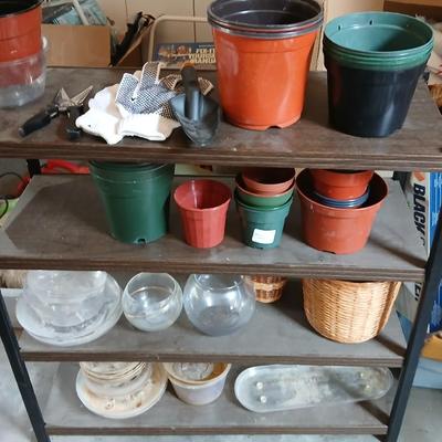 Lots of flowerpots and vases with a small metal shelf