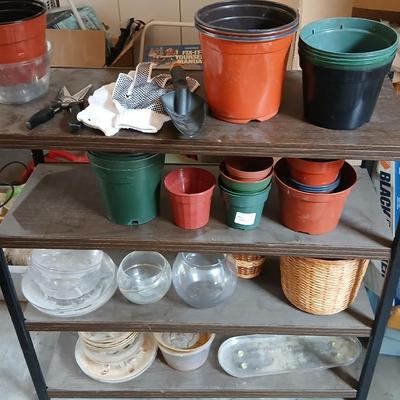 Lots of flowerpots and vases with a small metal shelf