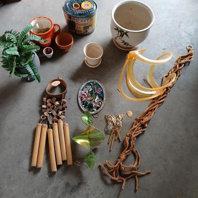 Ceramic plant pots and whirl gig yard art with a new pocket hose