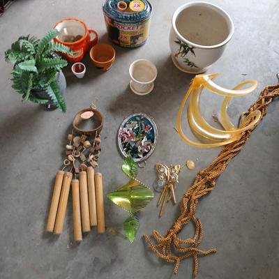 Ceramic plant pots and whirl gig yard art with a new pocket hose