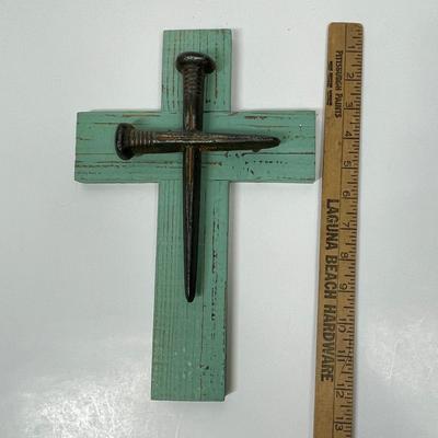 Painted wood cross with large nails or spikes.