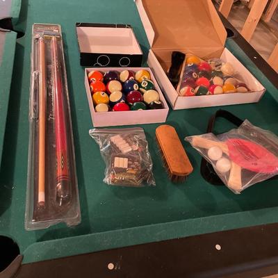 Smaller pool table with cues and stand