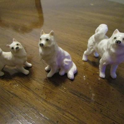 3 white ceramic American Eskimo dogs