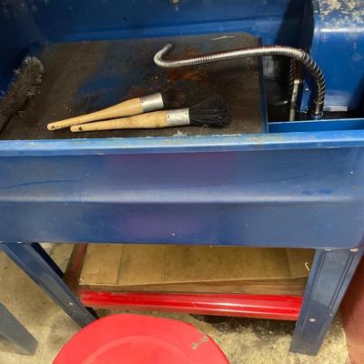 Small red stool with solvent parts cleaner