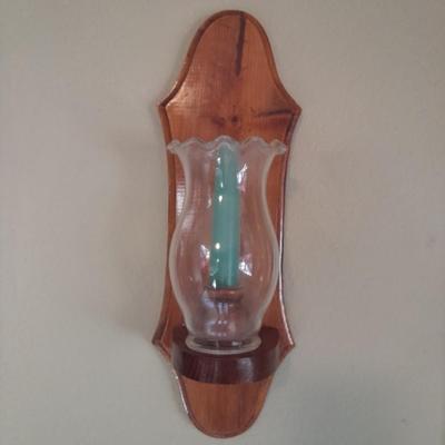 Large mirror with a pair of wooden candle sconces and a dried sash
