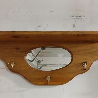 Small potted Live pathos plant on wooden stand and an oak mirrored wall shelf with hooks