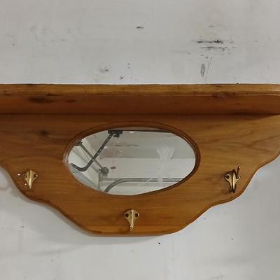Small potted Live pathos plant on wooden stand and an oak mirrored wall shelf with hooks