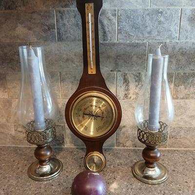 Two wooden base candle holders with globes and a thermometer barometer to hang on your wall