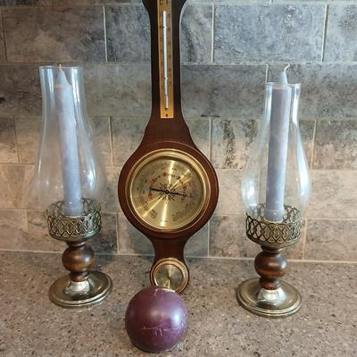 Two wooden base candle holders with globes and a thermometer barometer to hang on your wall