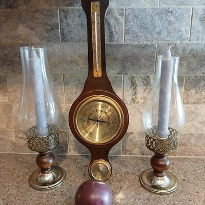 Two wooden base candle holders with globes and a thermometer barometer to hang on your wall