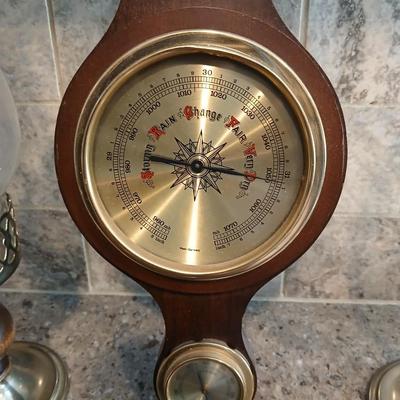 Two wooden base candle holders with globes and a thermometer barometer to hang on your wall
