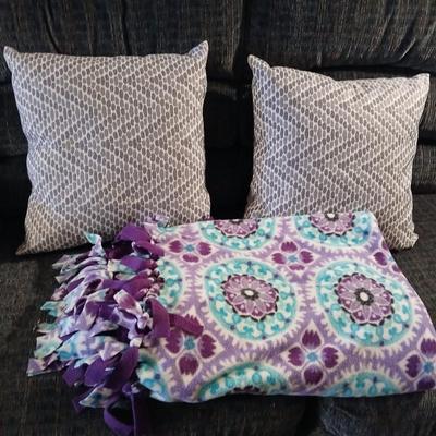 Two throw pillows and a homemade knotted blanket