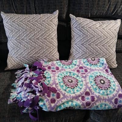 Two throw pillows and a homemade knotted blanket
