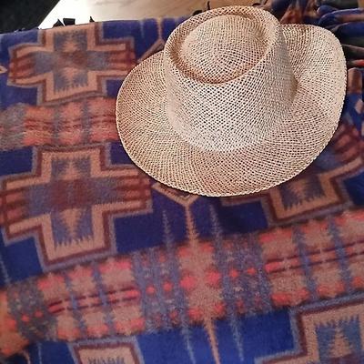 Homemade knotted blanket and a straw hat