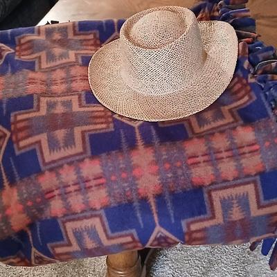 Homemade knotted blanket and a straw hat