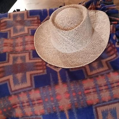 Homemade knotted blanket and a straw hat