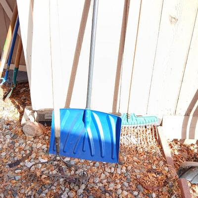 Yard tools - metal leaf rake, snow shovel, and a hard rake